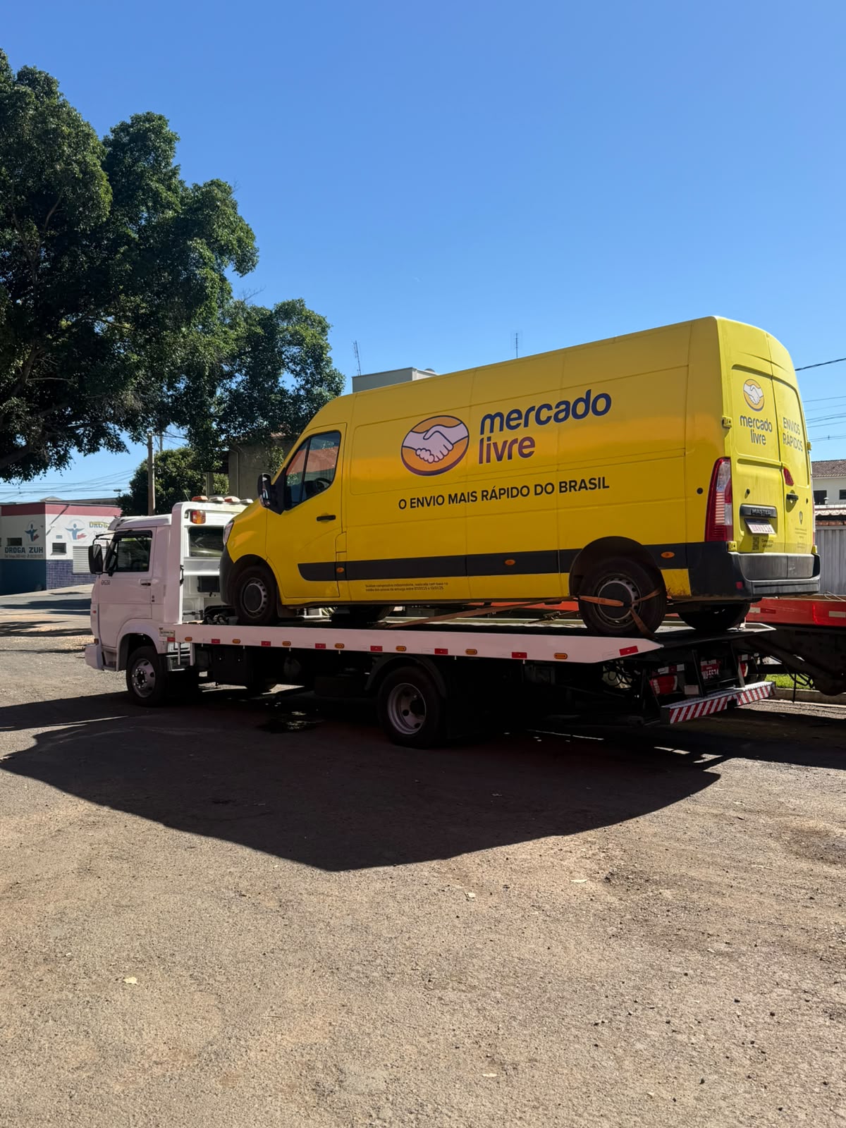 Guincho transportando van Mercado Livre amarela