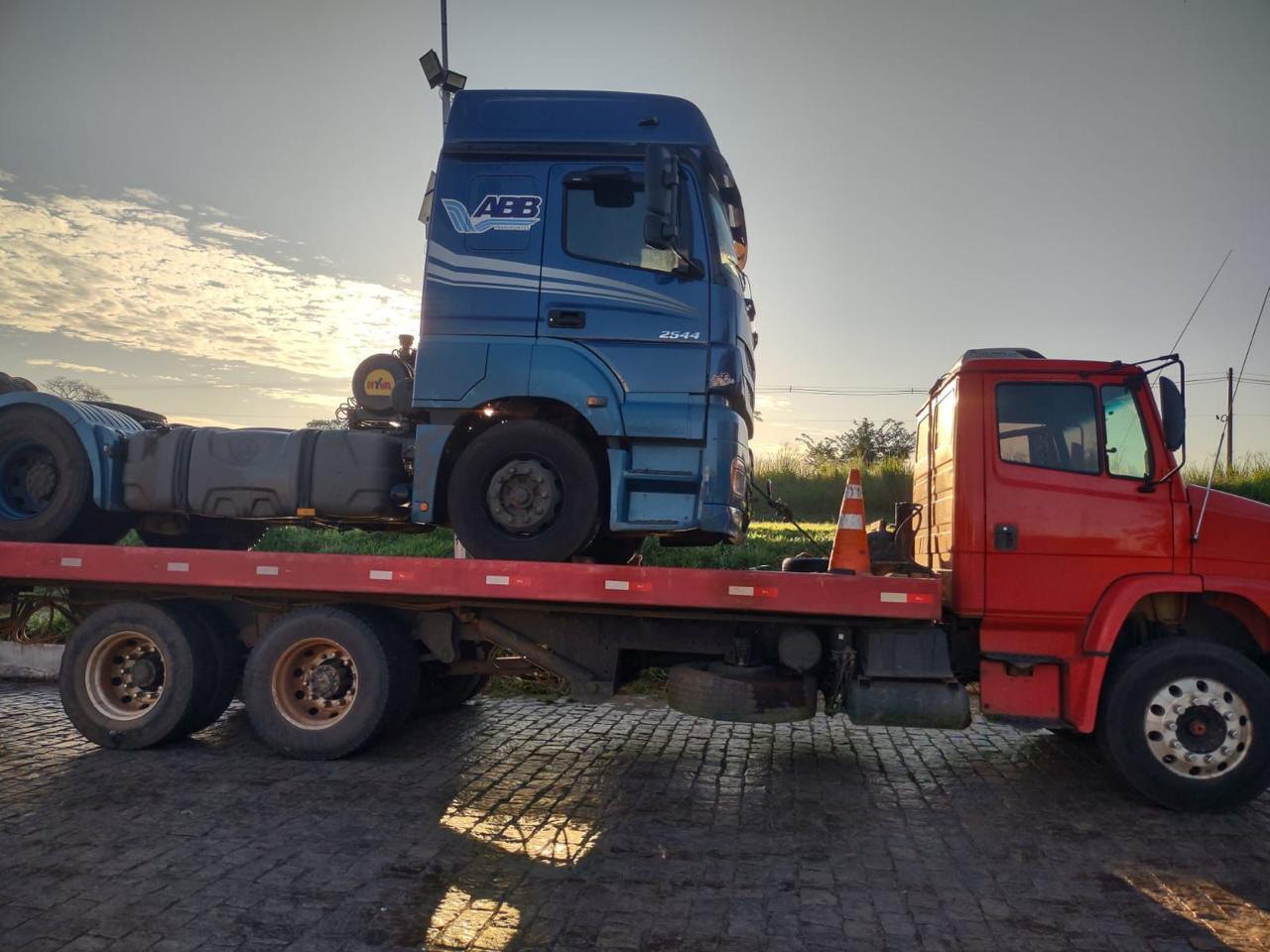 Guincho pesado transportando caminhão azul